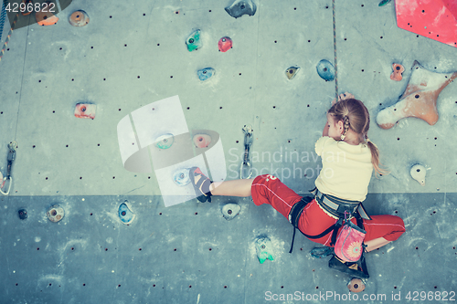 Image of little girl climbing a rock wall