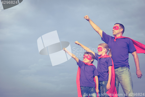 Image of Father and children playing superhero at the day time.