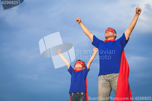 Image of Father and son playing superhero at the day time.