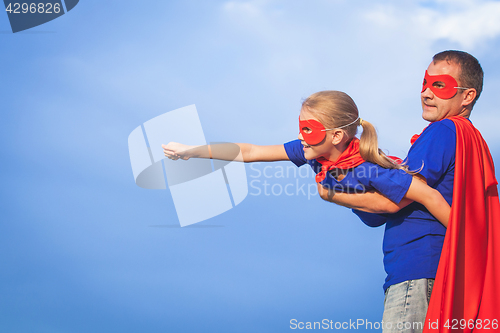 Image of Father and daughter playing superhero at the day time.