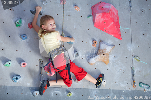 Image of little girl climbing a rock wall