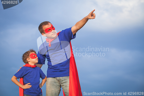 Image of Father and son playing superhero at the day time.