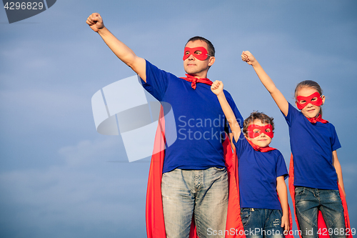 Image of Father and children playing superhero at the day time.