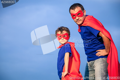 Image of Father and son playing superhero at the day time.