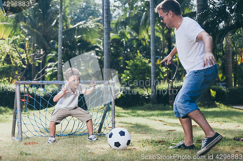 Image of Father and son playing in the park at the day time.