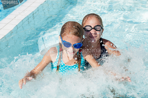 Image of Two happy children playing on the swimming pool at the day time.