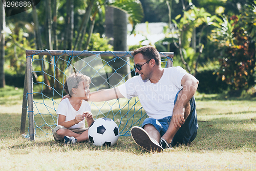 Image of Father and son playing in the park at the day time.