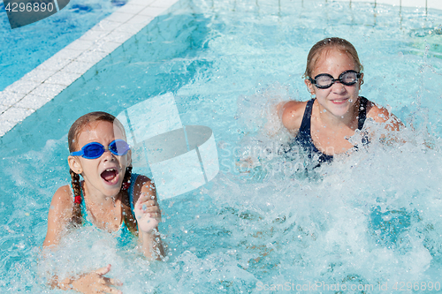 Image of Two happy children playing on the swimming pool at the day time.