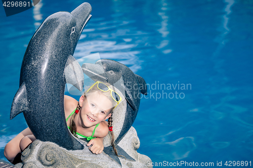 Image of One  happy little girl playing near swimming pool at the day tim