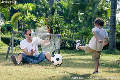 Image of Father and son playing in the park at the day time.