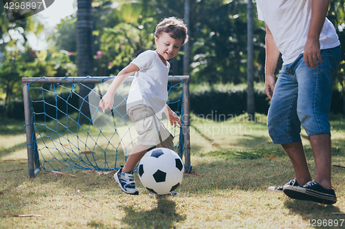 Image of Father and son playing in the park at the day time.