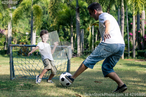 Image of Father and son playing in the park at the day time.