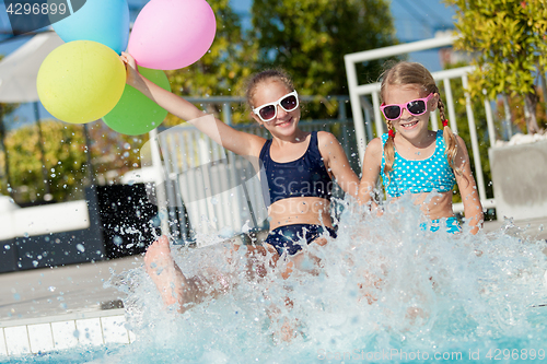 Image of Two happy children playing on the swimming pool at the day time.