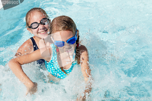 Image of Two happy children playing on the swimming pool at the day time.