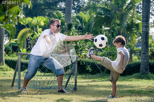 Image of Father and son playing in the park at the day time.