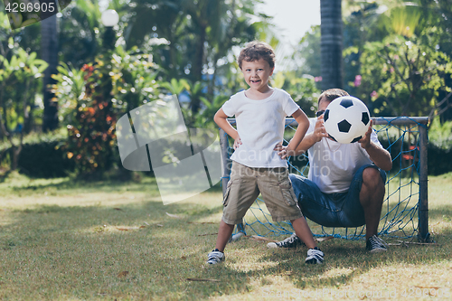 Image of Father and son playing in the park at the day time.