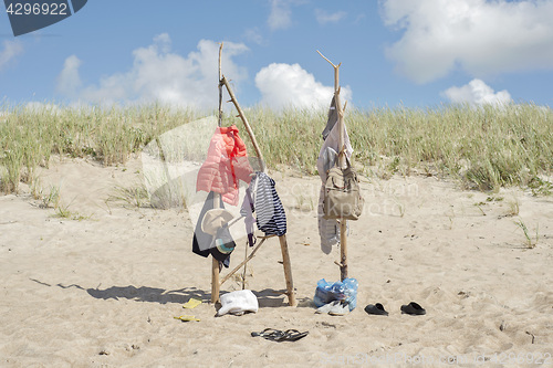 Image of clothes hanging on the wooden poles at the beach