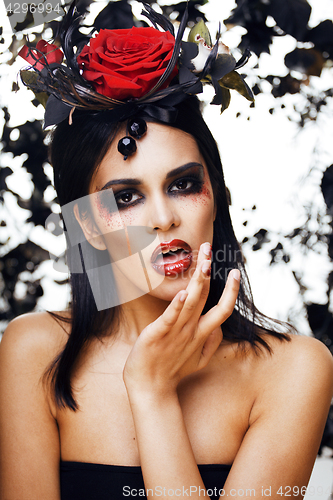 Image of pretty brunette woman with rose jewelry, black and red, bright make up like a vampire closeup red lips, halloween concept