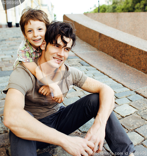 Image of Young father hipster and his little son outside. Talking, teaching, hugging, having fun happy time. Lifestyle people concept 