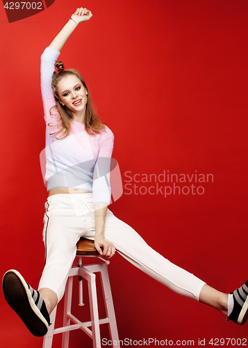 Image of young pretty emitonal posing teenage girl on bright red background, happy smiling lifestyle people concept 