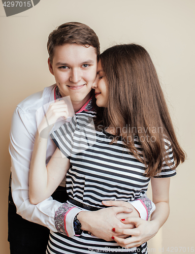 Image of couple of happy smiling teenagers students, warm colors having a kiss, lifestyle people concept, boy and girl together 