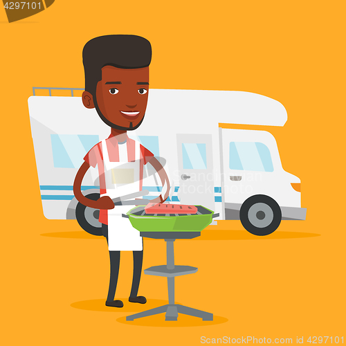 Image of Man having barbecue in front of camper van.