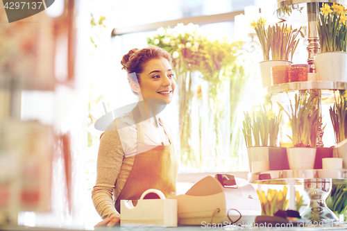 Image of smiling florist woman at flower shop cashbox