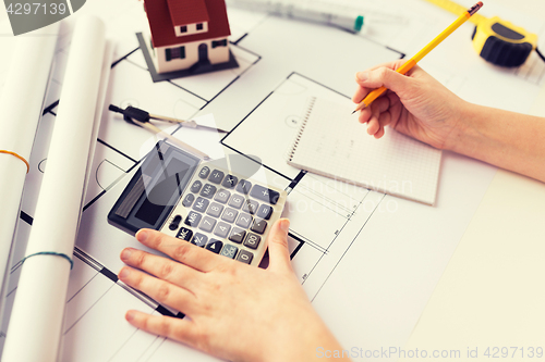 Image of close up of architect hand counting on calculator