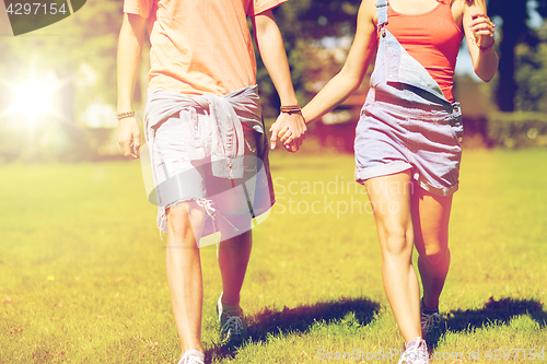 Image of happy teenage couple walking at summer park