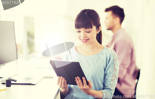 Image of happy creative female office worker with tablet pc