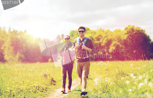 Image of happy couple with backpacks hiking outdoors