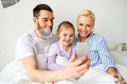 Image of happy family taking selfie by smartphone at home