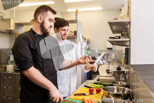 Image of two chefs cooking food at restaurant kitchen