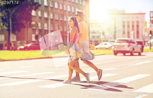 Image of teenage couple with skateboards on city street