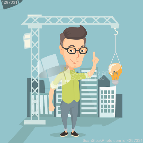 Image of Man pointing at idea bulb hanging on crane.