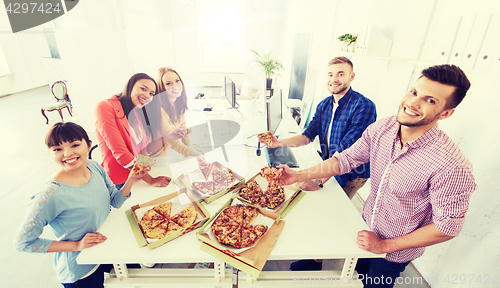 Image of happy business team eating pizza in office