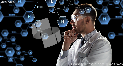 Image of scientist in goggles looking at chemical formula