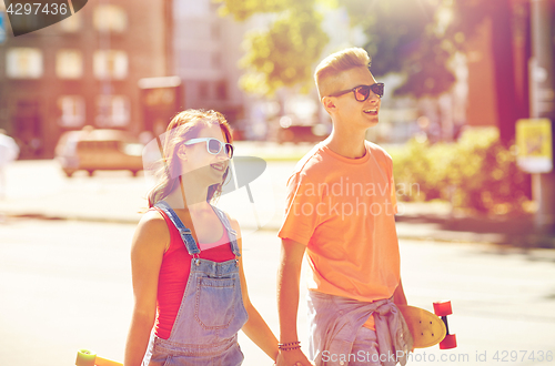 Image of teenage couple with skateboards on city street