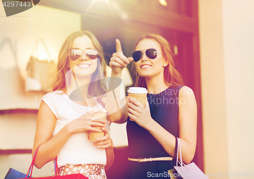 Image of young women with shopping bags and coffee at shop