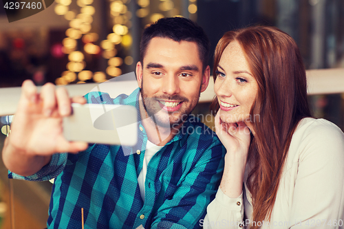 Image of couple taking selfie by smartphone at restaurant