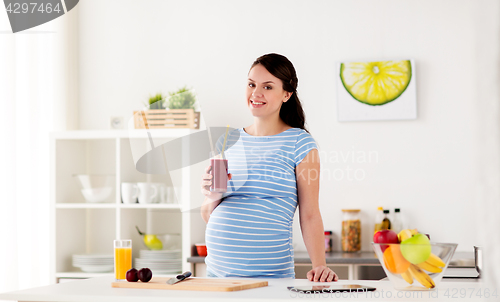 Image of happy pregnant woman drinking juice at home