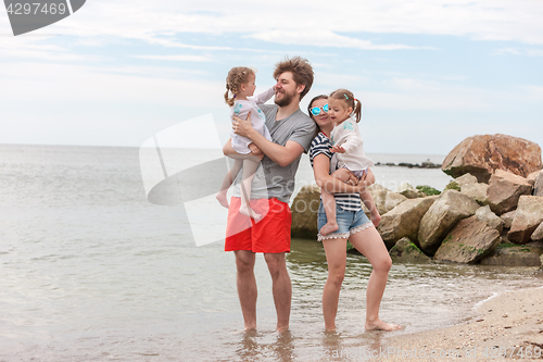 Image of Family vacation parents and children on the sea shore summer day