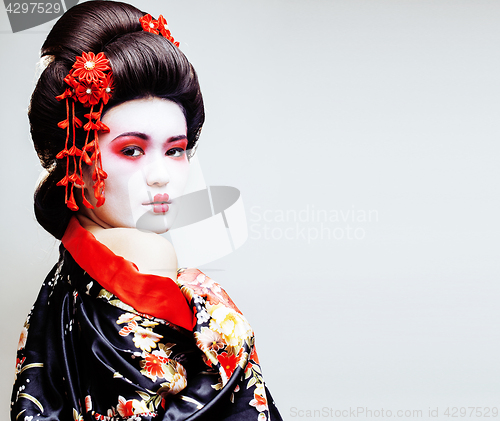 Image of young pretty geisha in kimono with sakura and red decoration des