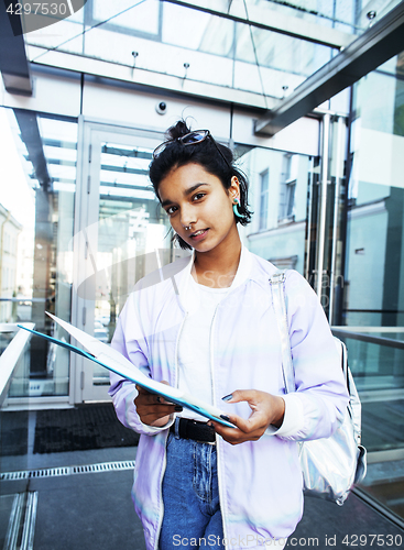 Image of young cute indian girl at university building sitting on stairs 