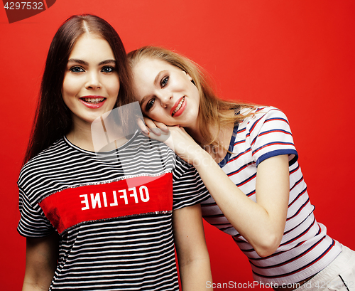 Image of two best friends teenage girls together having fun, posing emotional on red background, besties happy smiling, lifestyle people concept 