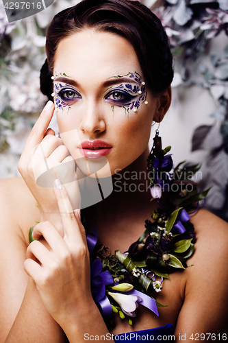 Image of floral face art with anemone in jewelry, sensual young brunette 