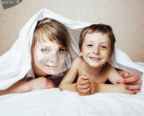 Image of young blond woman with little boy in bed, mother and son, happy 