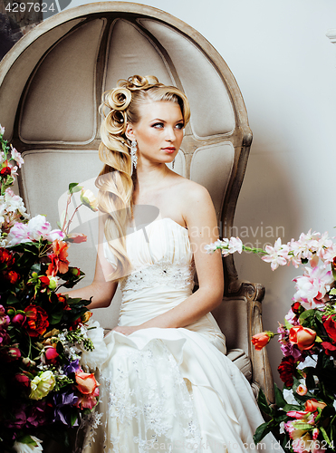 Image of beauty young blond woman bride alone in luxury vintage interior with a lot of flowers 