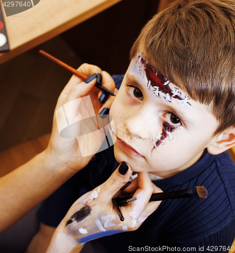 Image of little cute child making facepaint on birthday party, zombie Apo