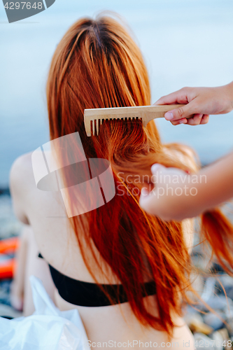 Image of Anonymous person brushing girl\'s hair